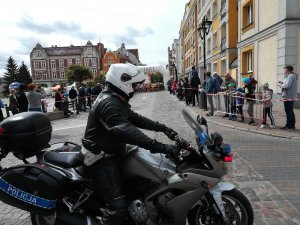 Policjant na motocyklu prowadzący  bieg czeka na start zawodników.