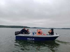 Policjant z dziećmi na łodzi motorowej