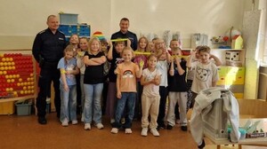 na załączonych zdjęciach widoczni są dwaj umundurowani policjanci - dzielnicowi i dzieci.