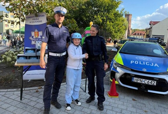 na zdjęciu nr 1 widoczni są dwaj umundurowani funkcjonariusze a pomiędzy nimi dziecko z kaskiem na głowie, na zdjęciu nr 2 widoczne jest dziecko z kaskiem na głowie, na pozostałych dwóch zdjęciach również widoczni są dwaj umundurowani funkcjonariusze z dzieckiem, które na głowie ma kask.