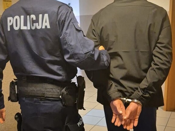 na załączonych zdjęciach widoczne jest wnętrze KPP w Człuchowie, a w nim  umundurowany Policjant, który prowadzi  mężczyznę - zatrzymanego,  który na ręce trzymane z tyłu ma założone kajdanki.