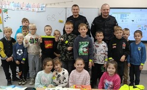 Dzielnicowi wśród najmłodszych. Rozmawiali o bezpieczeństwie. Na załączonych zdjęciach widoczni są umundurowani policjanci wśród dzieci, zdjęcia wykonywane są w sali- klasie, i na dworze.