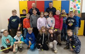 Dzielnicowi wśród najmłodszych. Rozmawiali o bezpieczeństwie. Na załączonych zdjęciach widoczni są umundurowani policjanci wśród dzieci, zdjęcia wykonywane są w sali- klasie, i na dworze.