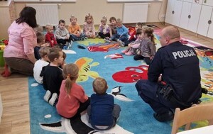 Dzielnicowi wśród najmłodszych. Rozmawiali o bezpieczeństwie. Na załączonych zdjęciach widoczni są umundurowani policjanci wśród dzieci, zdjęcia wykonywane są w sali- klasie, i na dworze.